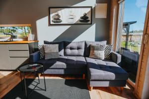 ein Wohnzimmer mit einem blauen Sofa und einem Tisch in der Unterkunft Seashore Holiday House in Saraiķi