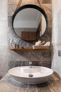 a bathroom with a white sink and a mirror at Olympus Pantheon Luxury Rooms in Plaka Litochorou