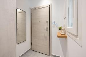 a bathroom with a wooden shower door and a mirror at Newly Renovated Escape/Psychiko in Athens