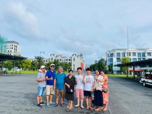 a group of people posing for a picture in a parking lot at Beach Hotel Grand World (La La Homestay) in Phu Quoc