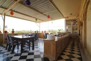 un restaurante con suelo a cuadros, mesas y sillas en Hotel Vasshifa Palace, en Jaisalmer