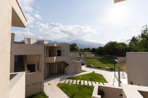 einem externen Blick auf ein Haus mit Blick auf einen Hof in der Unterkunft Olympus Pantheon Luxury Rooms in Plaka