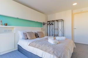 a bedroom with a large bed with white sheets at Birmingham City Centre Apartment in Birmingham