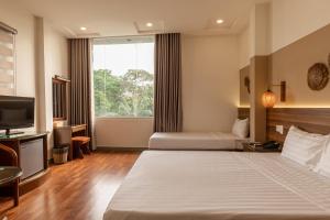 Habitación de hotel con 2 camas y TV en Lantern Hotel en Ho Chi Minh