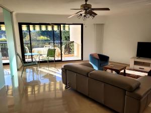 a living room with a brown couch and a table at Le Masters in Mandelieu-la-Napoule