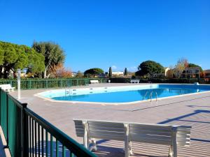 a swimming pool with a bench on a deck at Le Masters in Mandelieu-la-Napoule