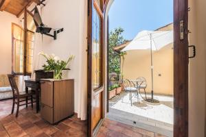 an open door to a patio with a table and an umbrella at Residenza Il Villino B&B in Florence