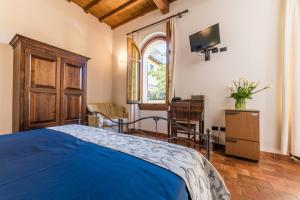 a bedroom with a blue bed and a television at Residenza Il Villino B&B in Florence
