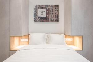 łóżko z białą pościelą i poduszkami w pokoju w obiekcie Newly Renovated Escape/Psychiko w Atenach