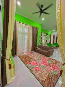 a living room with a couch and a ceiling fan at Airport Kelantan HOMESTAY & TRANSIT ROOM in Kota Bharu