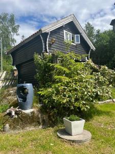 a house with two large pots in front of it at Stabbur Steinbekken, back to basic primitive overnight in Eidsvoll