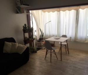 sala de estar con mesa blanca y sillas en ALCA Apartamento exclusivo a 80 mts de Playa Pocitos, en Montevideo