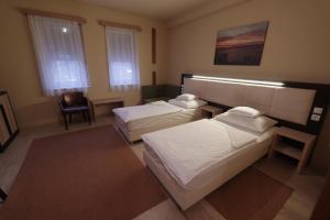 Łóżko lub łóżka w pokoju w obiekcie Hotel Vadászkürt Superior