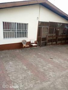 a building with two chairs in front of it at 2 bedroom Bungalow @ St John in Mount Aureol