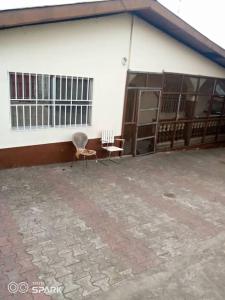 a building with two chairs sitting outside of it at 2 bedroom Bungalow @ St John in Mount Aureol