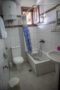 a bathroom with a tub and a toilet and a sink at Maries Thasos Stone Villa in Mariaí