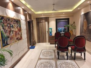 una sala d'attesa con sedie e un dipinto sul muro di Mavenoak Dreams B&B a Calcutta