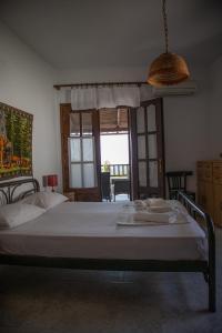 a bedroom with a bed and a large window at Maries Thasos Stone Villa in Mariaí