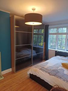 a bedroom with a bed and a large glass closet at The Gem - central character flat with parking in Southampton