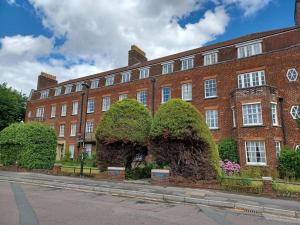 a large red brick building with bushes in front of it at The Gem - central character flat with parking in Southampton