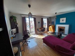 a living room with a purple couch and a table at The Gem - central character flat with parking in Southampton