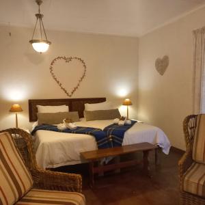 a bedroom with two beds and a heart on the wall at Autumn Breeze Manor Guest House in Graskop