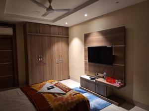a bedroom with a bed and a flat screen tv at Mavenoak Dreams B&B in Kolkata