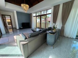 uma sala de estar com um sofá e uma televisão em Ocean Palms Luxury Villa Bangtao Beach Phuket em Praia de Bang Tao