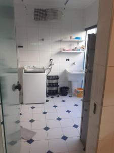a small bathroom with a white and blue tiled floor at Casa em Riviera de São Lourenço in Bertioga