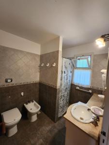 een badkamer met een toilet, een wastafel en een douche bij Solar Encantado Cabañas & Chalet in Villa General Belgrano