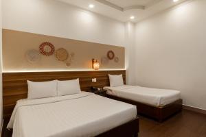 een hotelkamer met 2 bedden en een nachtjapon bij Lantern Hotel in Ho Chi Minh-stad