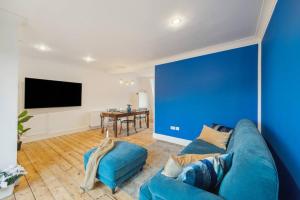 a blue wall in a living room with a blue couch at Chelsea Superior Apartment - 10 Minutes from Stadium in London