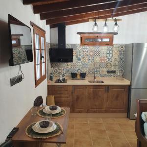 a kitchen with a table and a stainless steel refrigerator at La Gallania de Papá Pepe in Santa Lucía