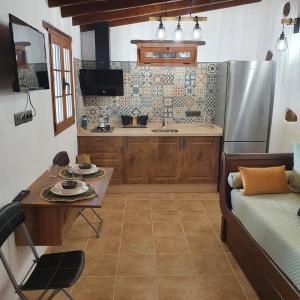 a kitchen with a couch and a table and a refrigerator at La Gallania de Papá Pepe in Santa Lucía