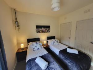 two beds in a room with two lights on at Large 3 bed, great for contractors, with private parking in Provanmill