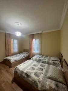 a bedroom with two beds and a chandelier at Los-Polos Hermanos in Batumi