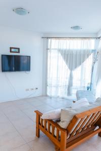 ein Zimmer mit einem Bett und einem Fernseher an der Wand in der Unterkunft PH Patagonia Barrancas al Mar 2 in Puerto Madryn