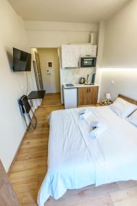 ein großes weißes Bett in einem Zimmer mit Küche in der Unterkunft Luxury apartment B5 - Thessaloniki Center in Thessaloniki