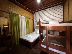 Cette chambre comprend 2 lits superposés et une fenêtre. dans l'établissement Mount Pinatubo Base Camp at CASA HERMOGINA, à Santa Juliana