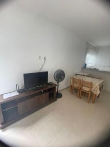 uma sala de estar com uma televisão de ecrã plano e uma mesa em Praia dos ingleses Floripa em Florianópolis