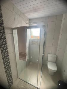 a bathroom with a toilet and a glass shower at Praia dos ingleses Floripa in Florianópolis