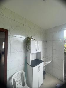 baño blanco con lavabo y armario blanco en Praia dos ingleses Floripa en Florianópolis