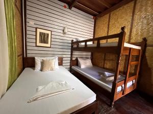 a bedroom with two bunk beds in a cabin at Mount Pinatubo Base Camp at CASA HERMOGINA in Santa Juliana