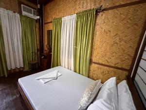a bed in a room with green curtains at Mount Pinatubo Base Camp at CASA HERMOGINA in Santa Juliana