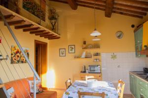 Un comedor con una mesa y una cocina. en Suite San Martino - Cecina Riparbella casa vacanze, en Riparbella
