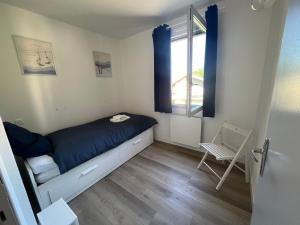 una piccola camera da letto con un letto e una finestra di Ourea a Savignac-les-Ormeaux