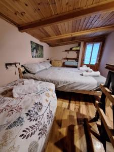 two beds in a room with wooden ceilings at Il Ciabot del Bosco in Frassino