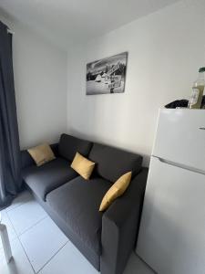 un soggiorno con divano e frigorifero di Ourea a Savignac-les-Ormeaux