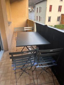 un tavolo e sedie seduti su un balcone di Ourea a Savignac-les-Ormeaux