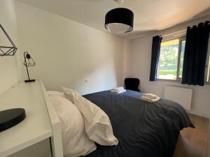 una camera da letto con un letto, una scrivania e una finestra di Ourea a Savignac-les-Ormeaux